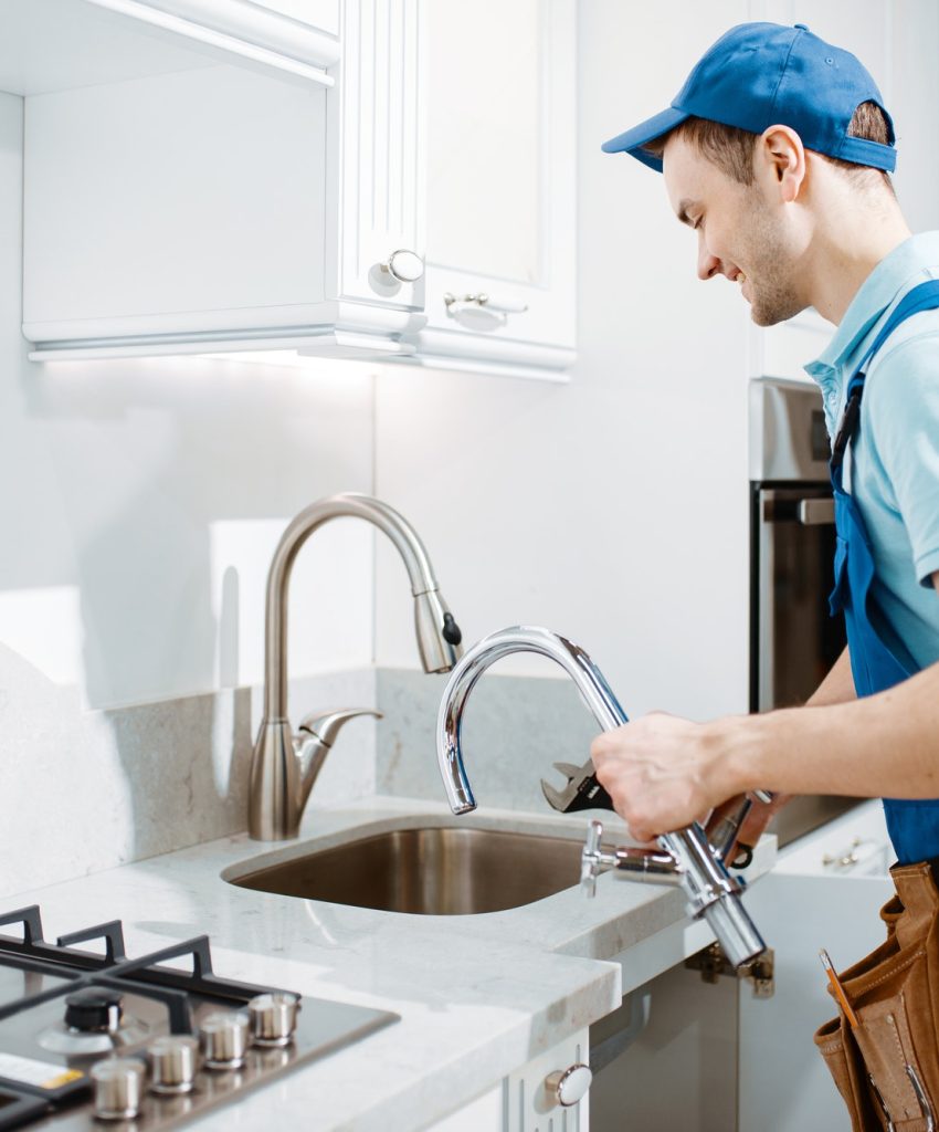 plumber-in-uniform-changes-faucet-in-the-kitchen.jpg plumber-in-uniform-changes-faucet-in-the-kitchen.jpg